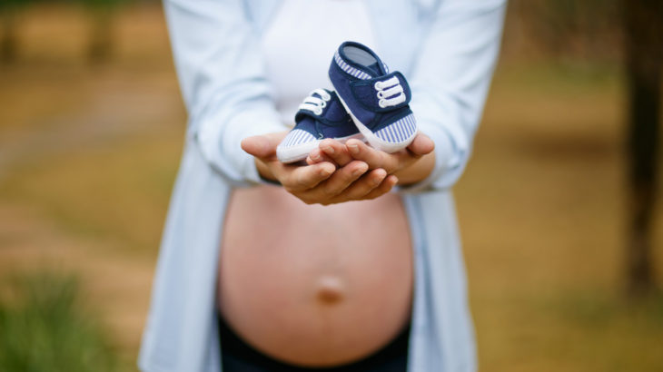 pregnancy-tummy-holding-tiny-shoes